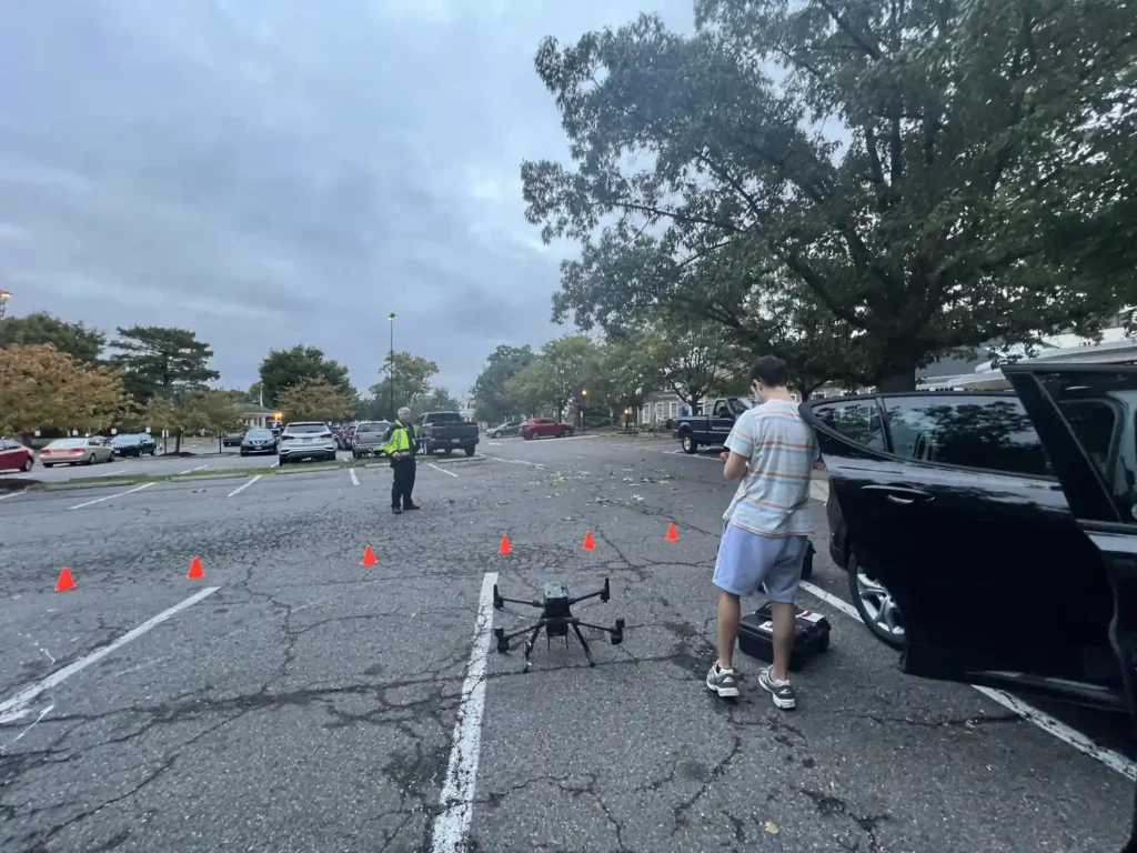 Drone set up on a parking lot between traffic cones as a crew member prepares to fly