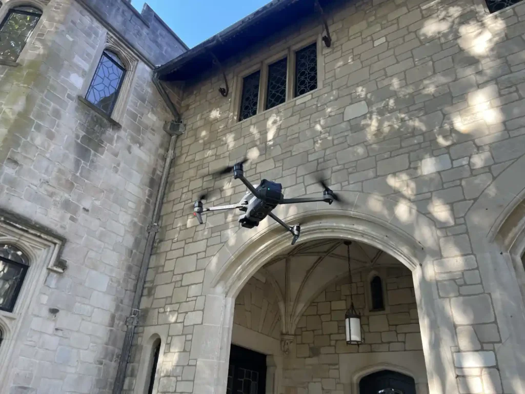 Harkin drone flying near the stone arches of a campus building