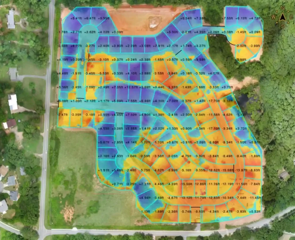 Cut and fill map over aerial imagery of a graded site, with colored zones and grid values